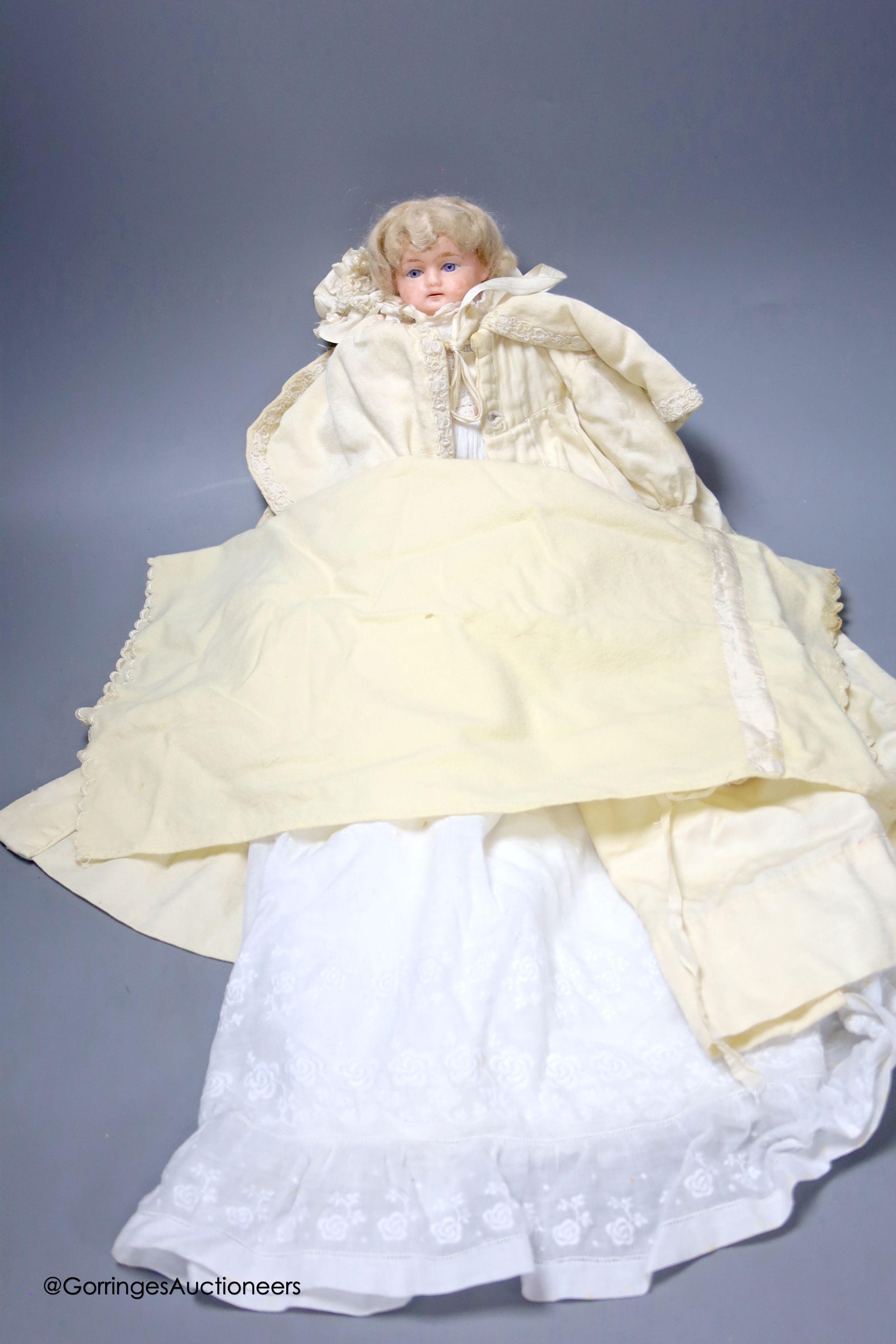 An antique wax doll, in original christening clothes, neck repaired, 12ins